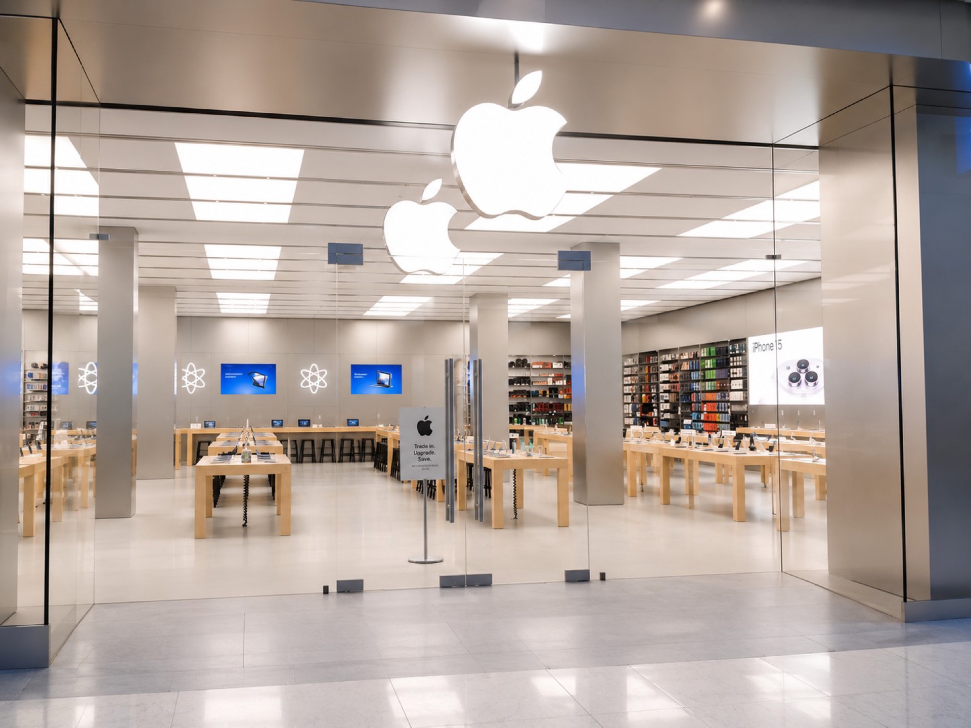 Frameless glass entrance doors of the Apple store with the sales floor beyond