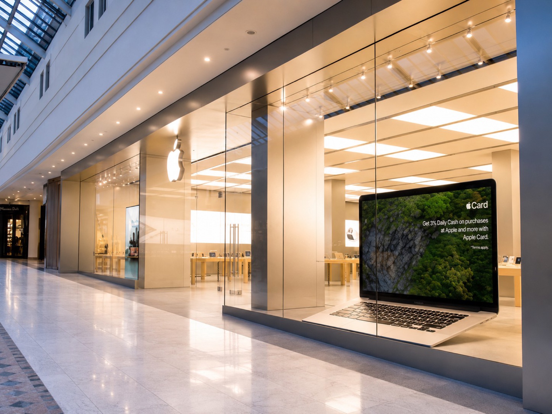 Angled view of the frameless glass Apple storefront with stainless steel surround