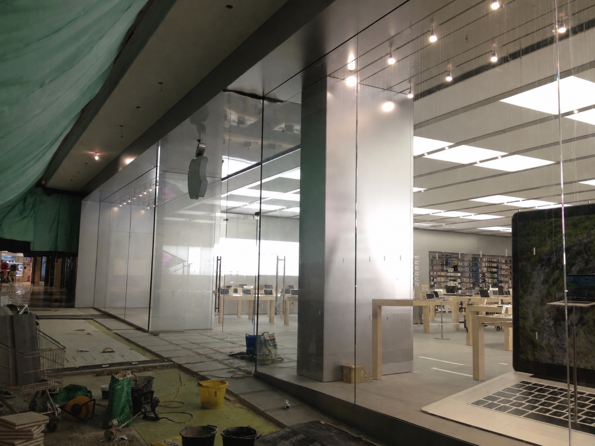 Full-height structural glass and stainless steel columns during an Apple store fit-out