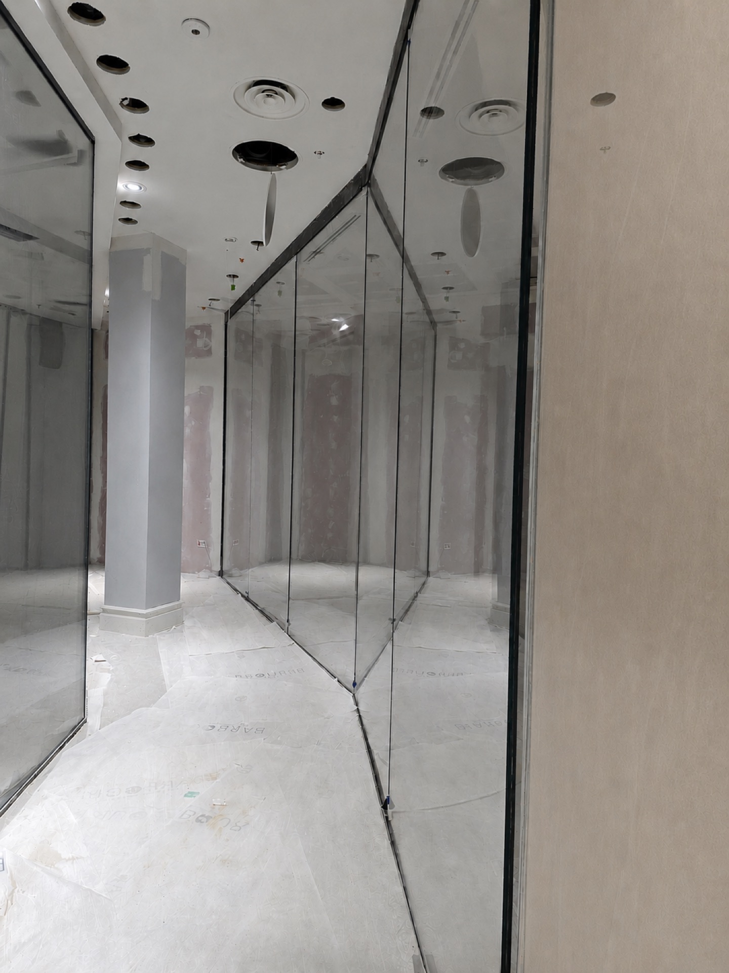 Frameless glass display screens meeting at a corner with glass-to-glass joints