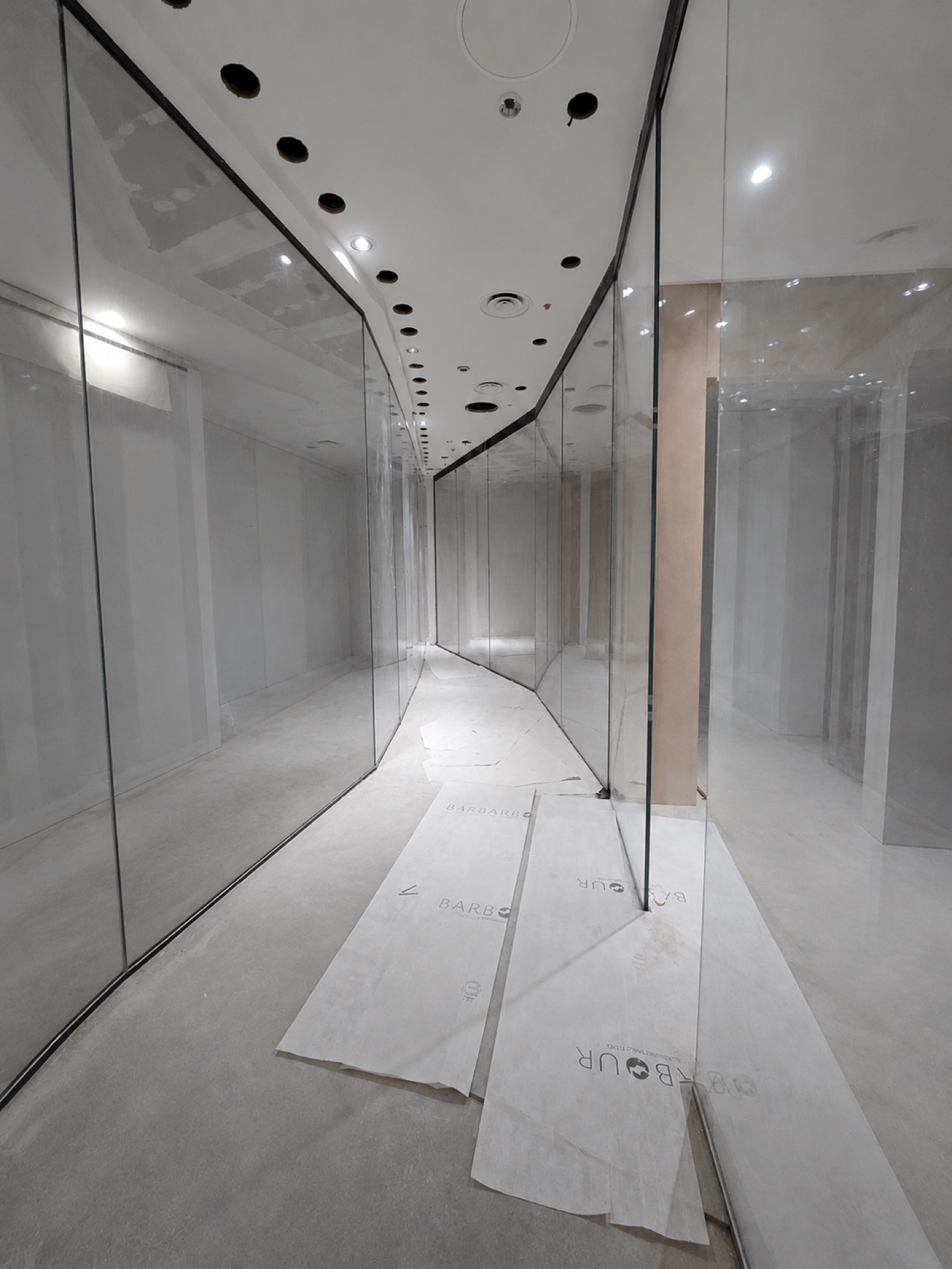 Frameless glass window bed screens during installation in a jewellery store fit-out