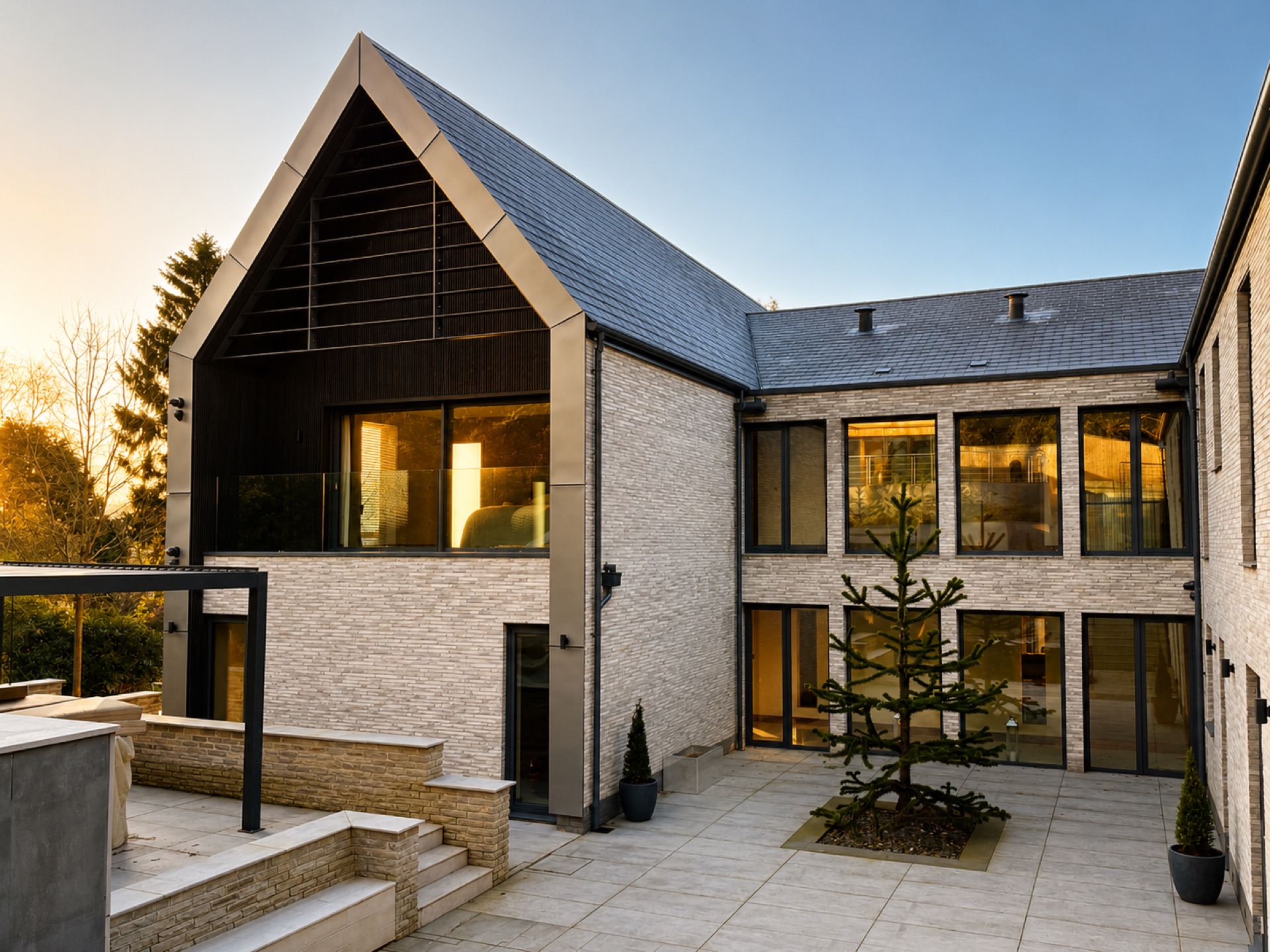 Courtyard of an Ilkley home showing stone walls, slate roof and dark aluminium glazing