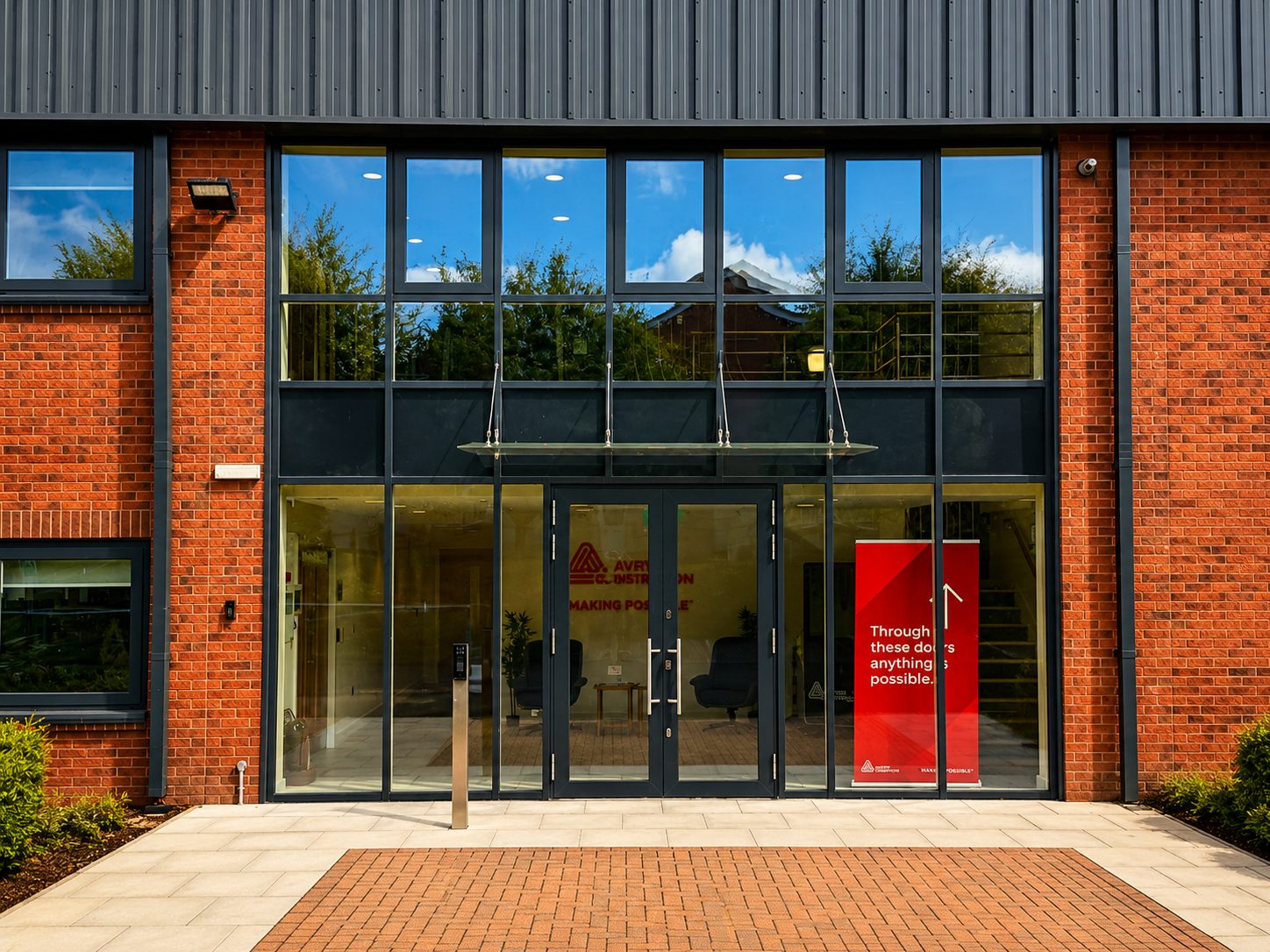 Aluminium-framed glazed entrance and screen on a red brick office building