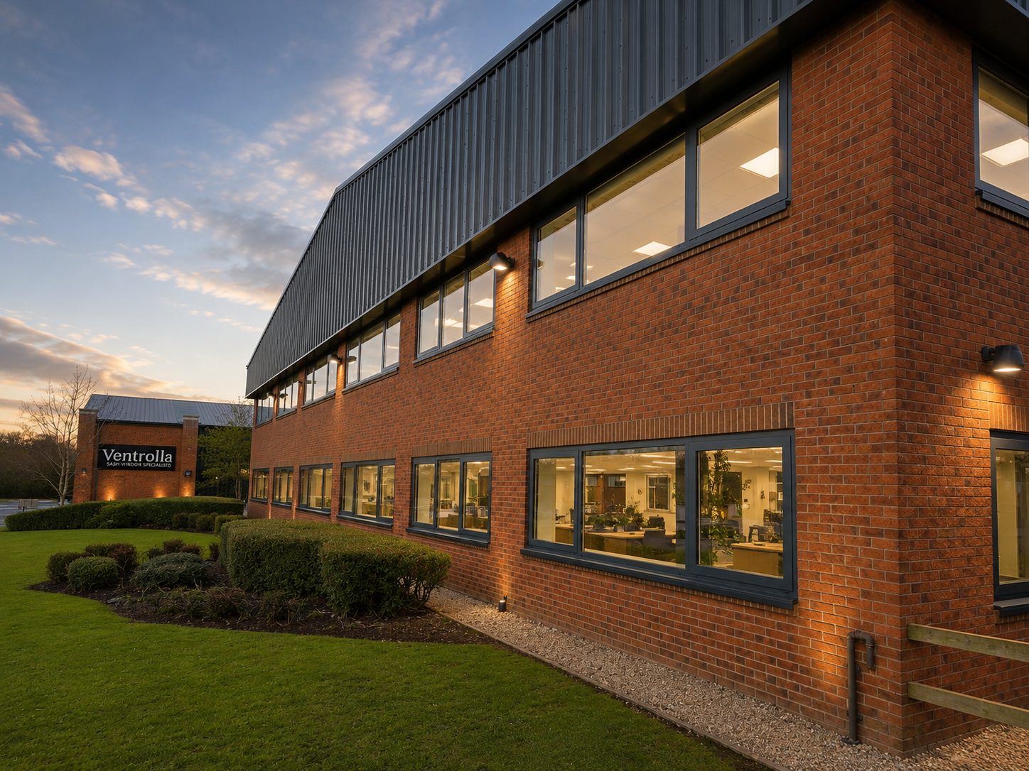 Aluminium windows on a two-storey red brick office building at dusk