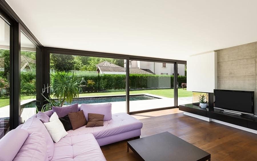 Aluminium sliding doors from a lounge onto a garden