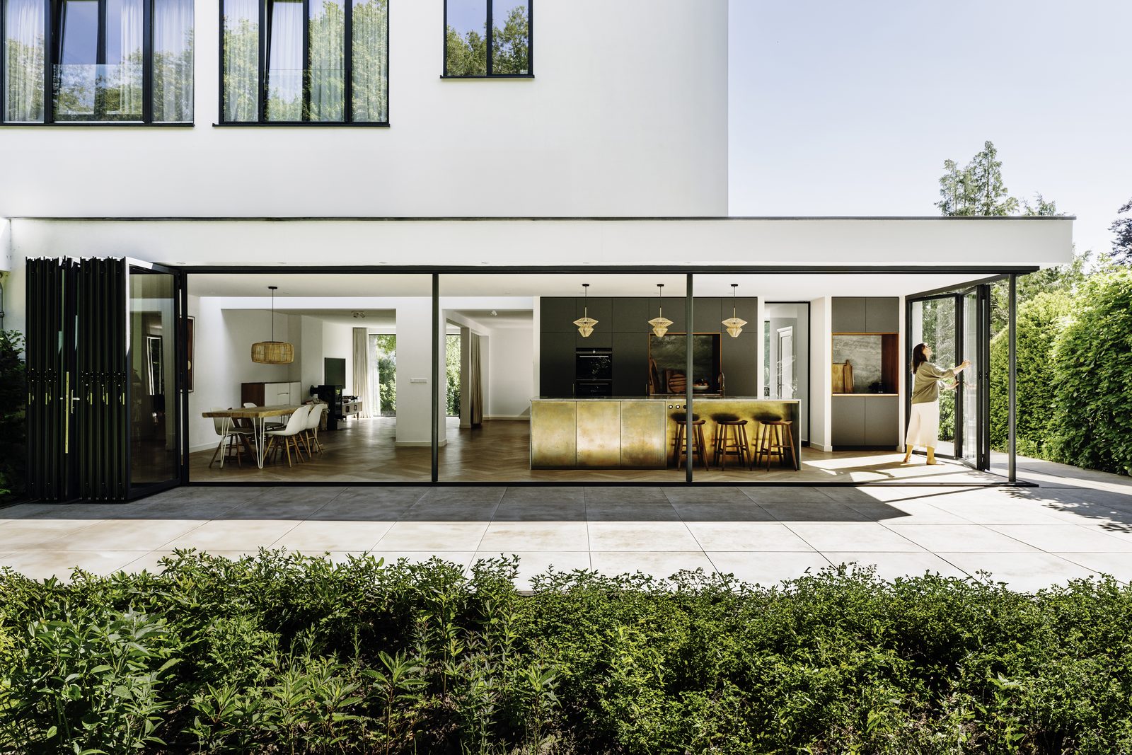 Solarlux cero sliding glass doors fully open across the ground floor of a white house